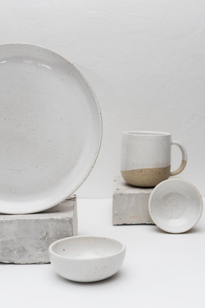Elegantly crafted white ceramic tableware featuring a bowl, plate, and mug in a minimalist design.